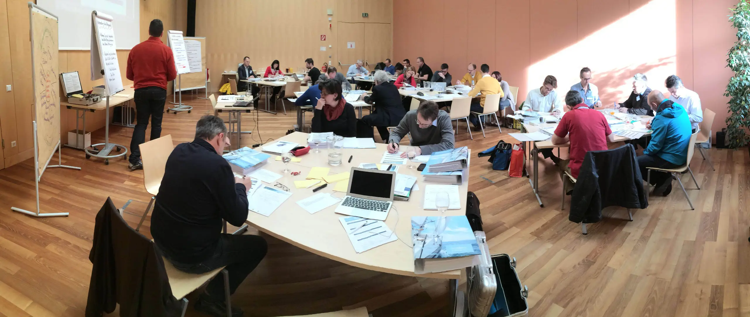 Teilnehmer in Arbeitsgruppen mit Unterlagen – Richard Zauner Exzellenmanagement Verkaufsseminar mit großer Gruppe